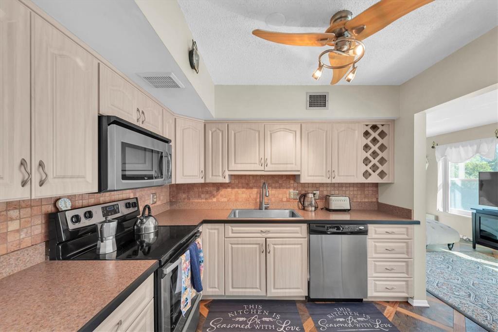 2469 Franciscan Drive, Unit 53 Clearwater, FL 33763 - Photo 13 of 51 a kitchen with stainless steel appliances granite countertop a sink stove and cabinets