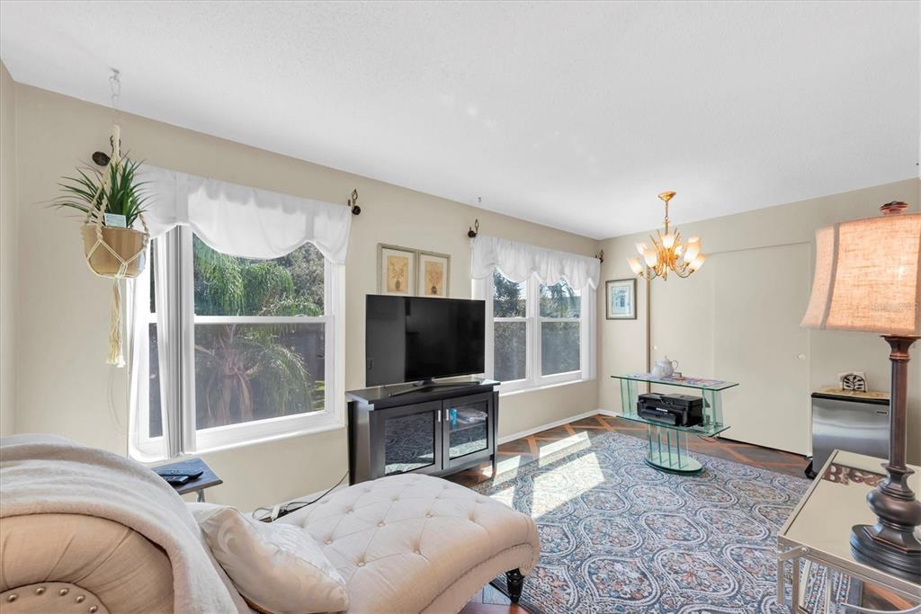 2469 Franciscan Drive, Unit 53 Clearwater, FL 33763 - Photo 14 of 51 a living room with furniture a chandelier and a flat screen tv
