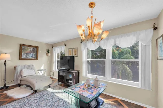 a living room with furniture a flat screen tv and a large window