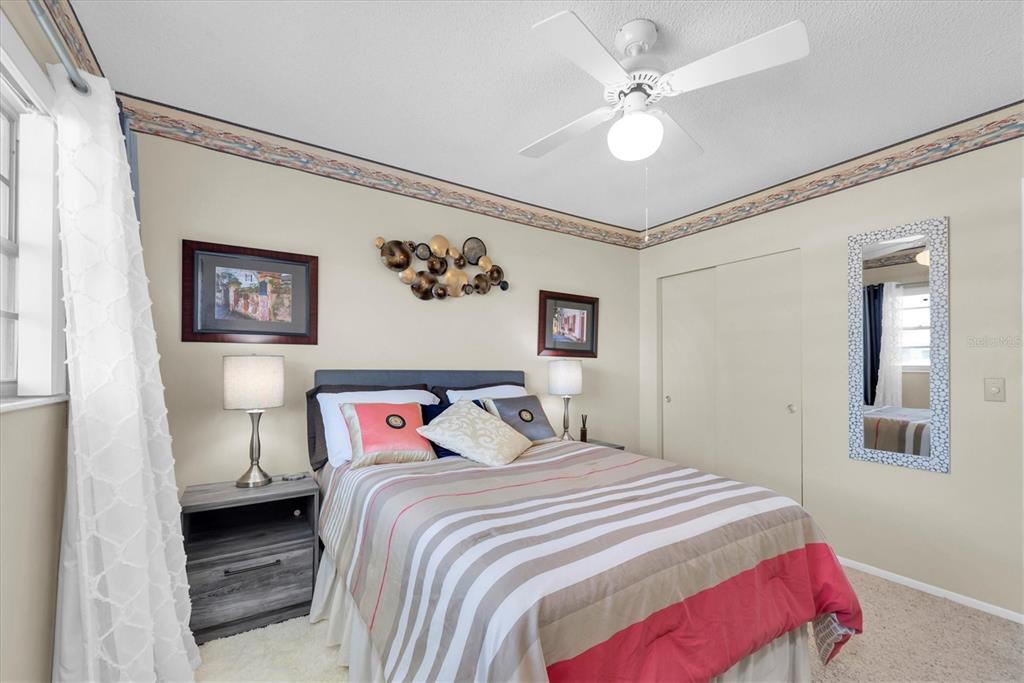 2469 Franciscan Drive, Unit 53 Clearwater, FL 33763 - Photo 22 of 51 a bedroom with a large bed and a chandelier