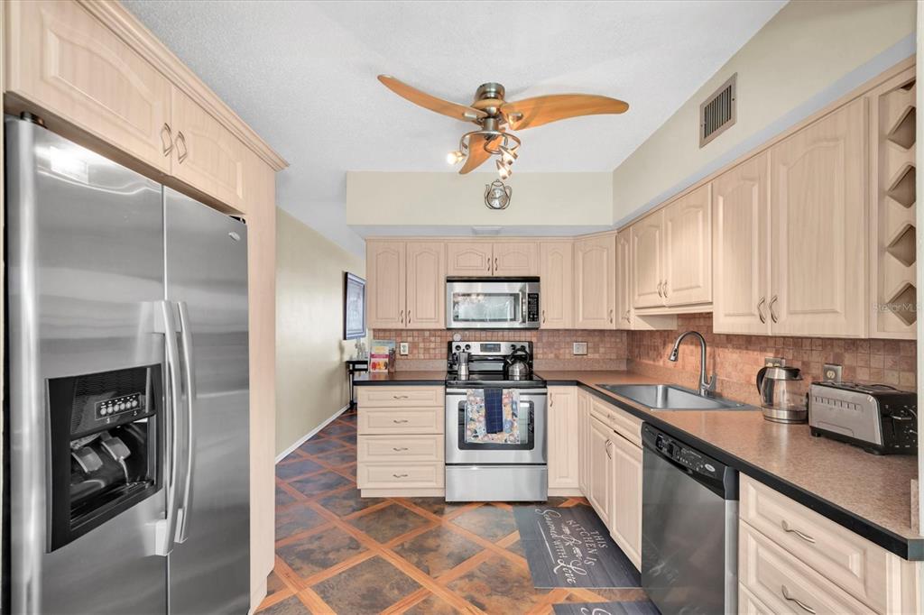 2469 Franciscan Drive, Unit 53 Clearwater, FL 33763 - Photo 10 of 51 a kitchen with a refrigerator a sink and cabinets