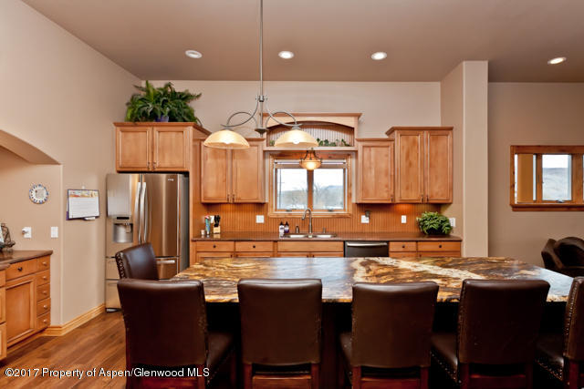 454 35 Road Palisade, CO 81526 - Photo 6 of 28 a dining hall with stainless steel appliances kitchen island granite countertop a dining table chairs and a refrigerator