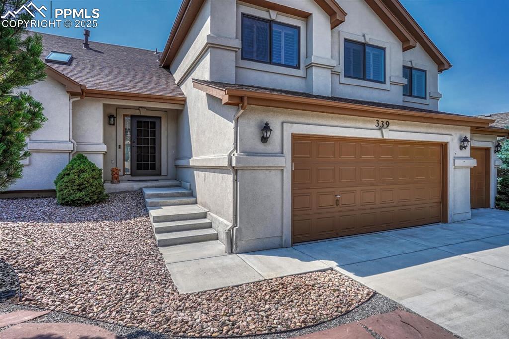 339 Sandreed Place Colorado Springs, CO 80921 - Photo 2 of 50 View of front facade with stucco siding, an attached garage, driveway, and a shingled roof