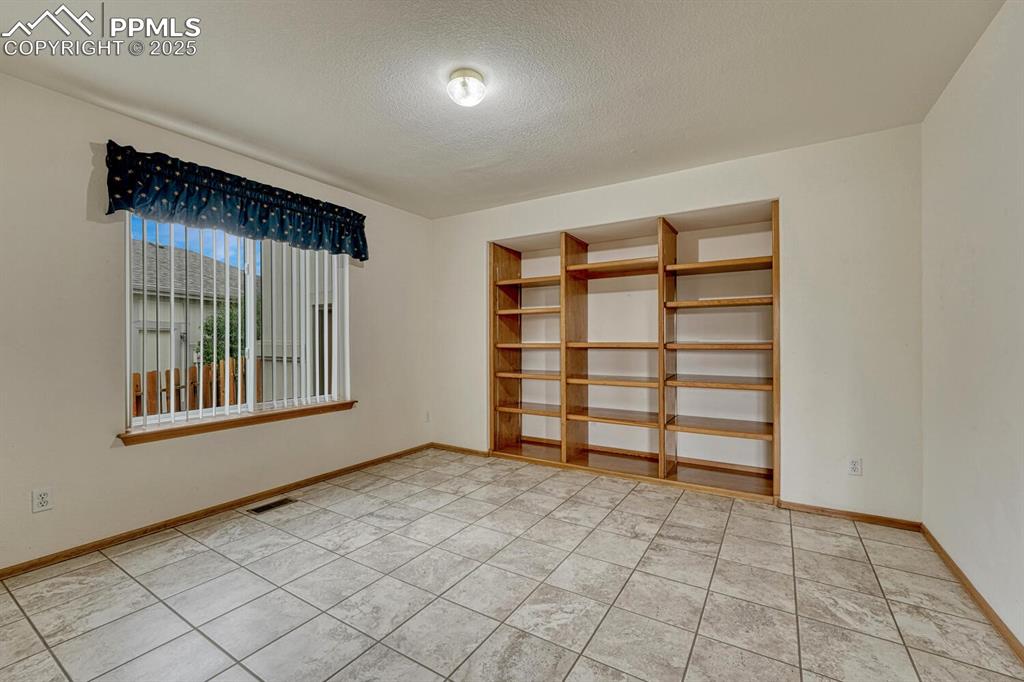 339 Sandreed Place Colorado Springs, CO 80921 - Photo 21 of 50 Empty room with a textured ceiling and light tile patterned floors