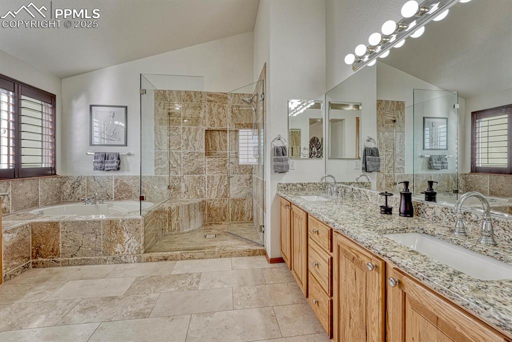 339 Sandreed Place Colorado Springs, CO 80921 - Photo 27 of 50 Full bathroom with double vanity, lofted ceiling, a bath, and a shower stall