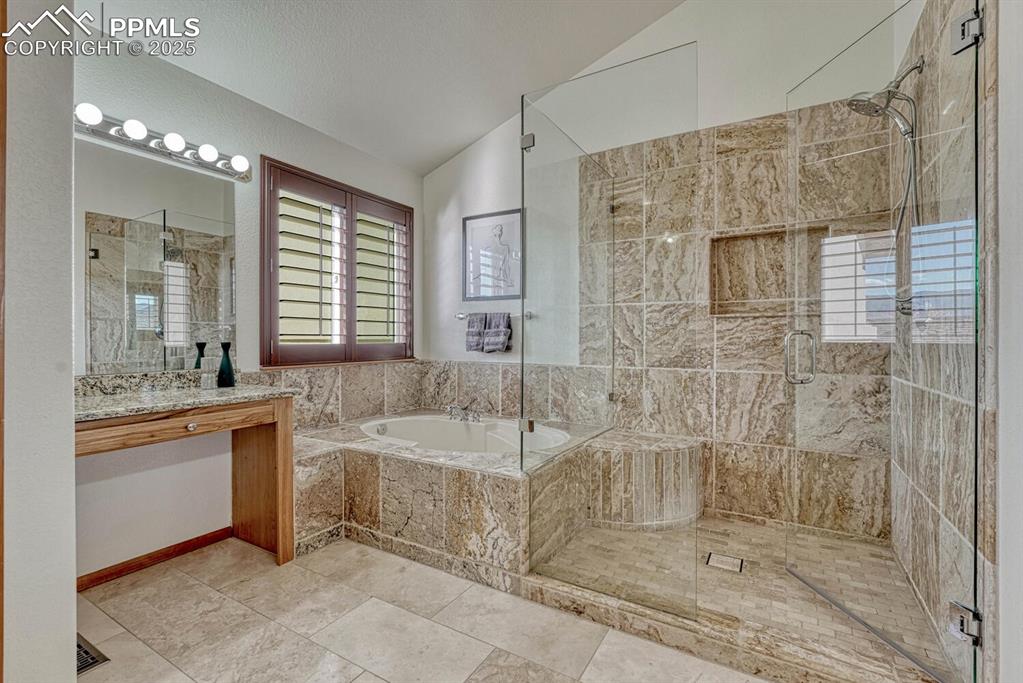 339 Sandreed Place Colorado Springs, CO 80921 - Photo 28 of 50 Bathroom with lofted ceiling, a garden tub, a shower stall, vanity, and light tile patterned flooring