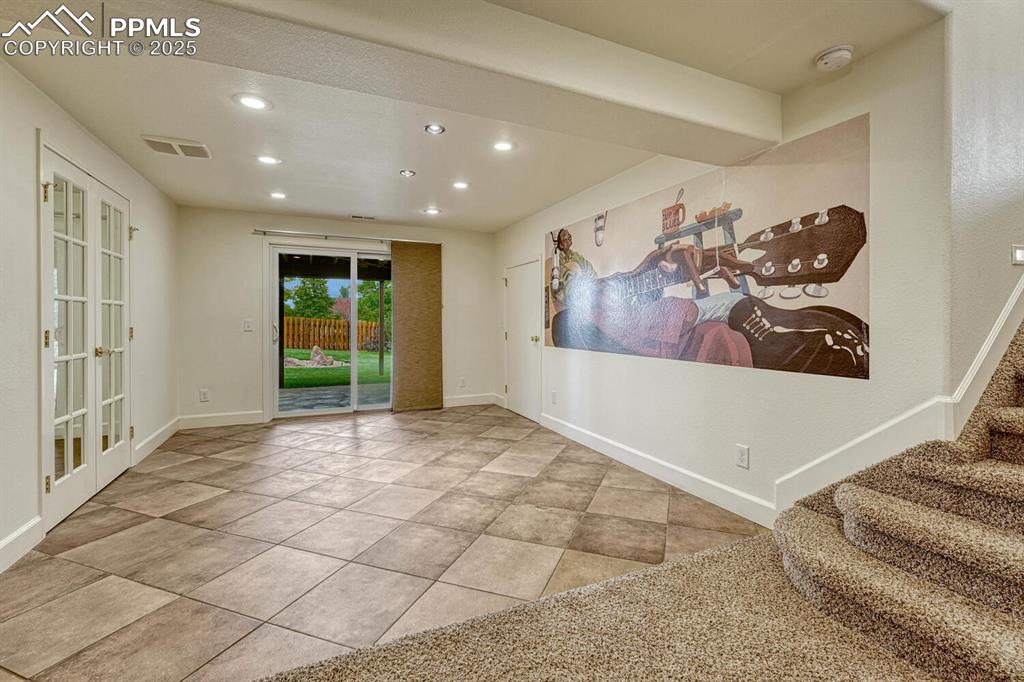 339 Sandreed Place Colorado Springs, CO 80921 - Photo 34 of 50 Carpeted spare room with recessed lighting, french doors, tile patterned floors, and stairway