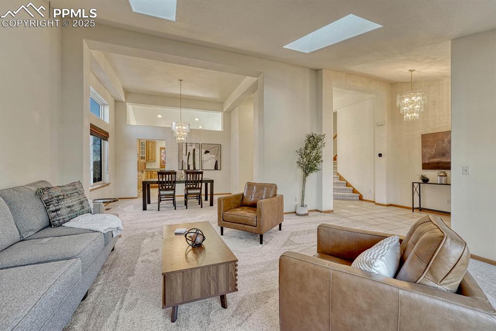 339 Sandreed Place Colorado Springs, CO 80921 - Photo 7 of 50 Living area with a chandelier, carpet flooring, a skylight, and stairs
