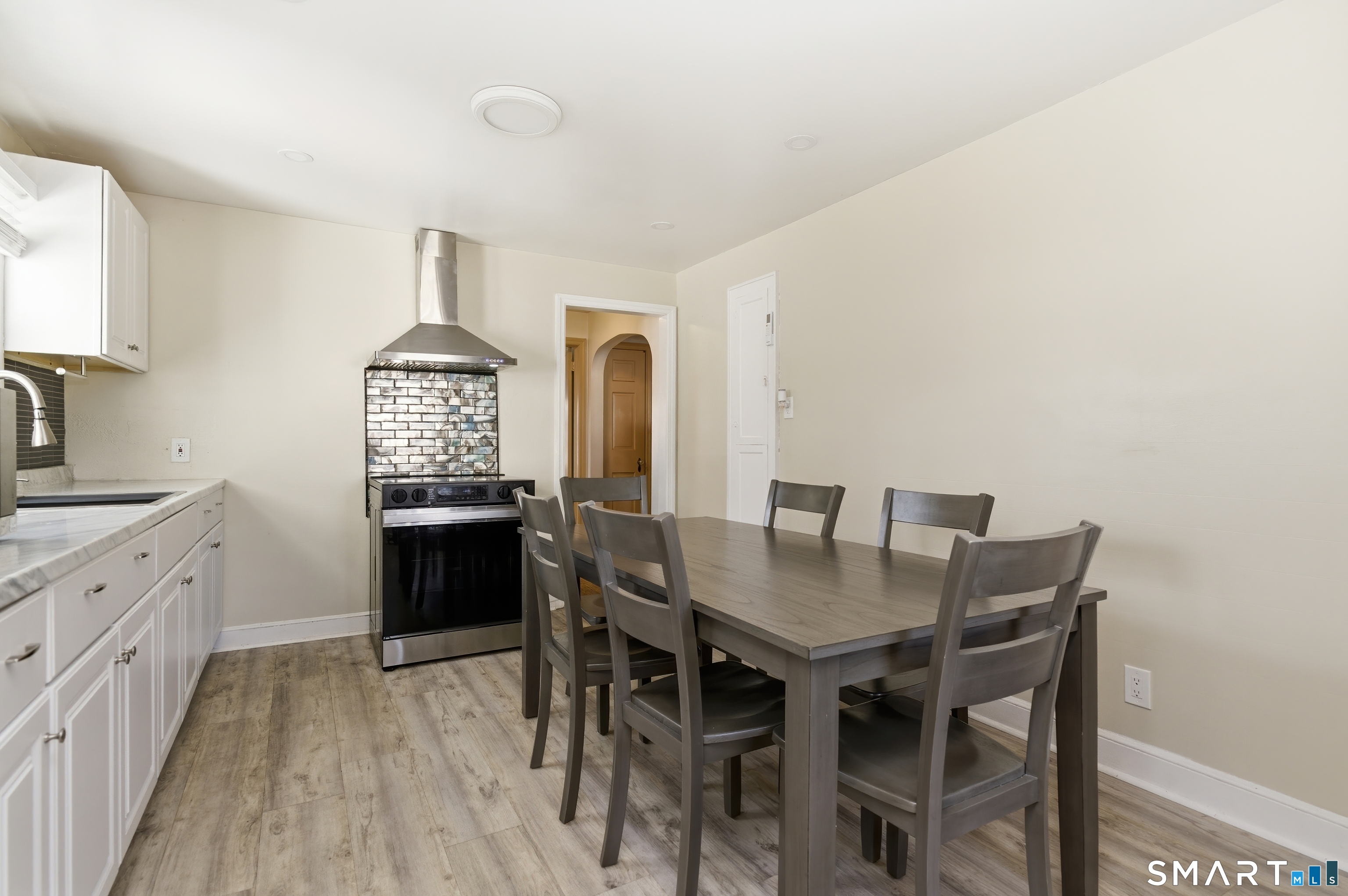170 Hillside Avenue Bridgeport, CT 06604 - Photo 8 of 35 a view of a kitchen area with furniture and wooden floor