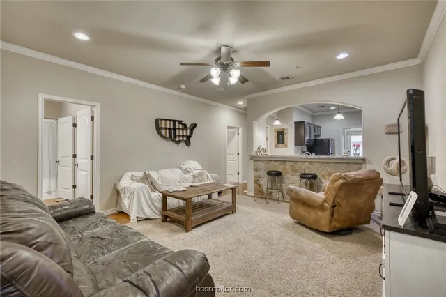 a living room with furniture and a view of kitchen