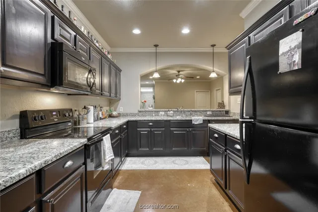 a large kitchen with stainless steel appliances granite countertop a stove a sink and a refrigerator