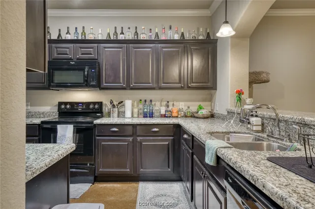 a kitchen with stainless steel appliances granite countertop a sink stove and cabinets