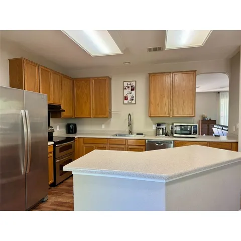 a kitchen with stainless steel appliances granite countertop a sink stove and refrigerator