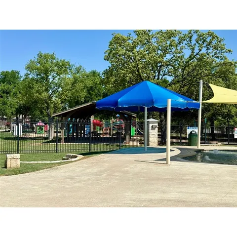a view of a garden with a bench under an umbrella