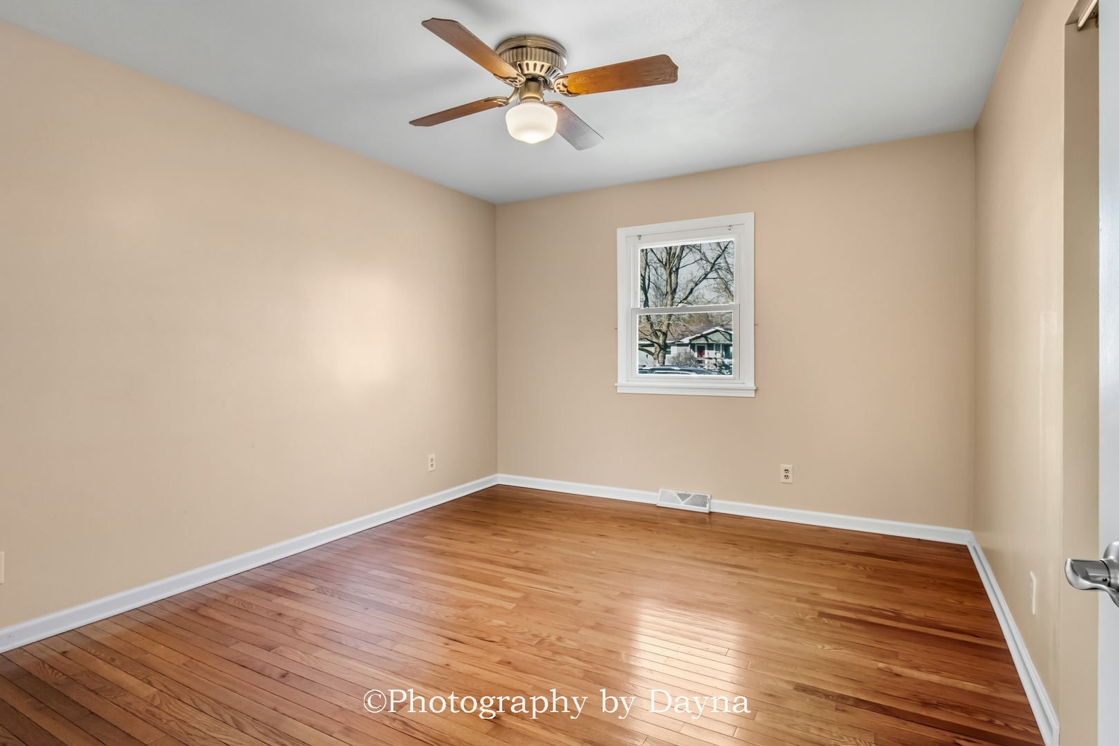 711 Sycamore Street Watseka, IL 60970 - Photo 11 of 21 an empty room with wooden floor and a ceiling fan
