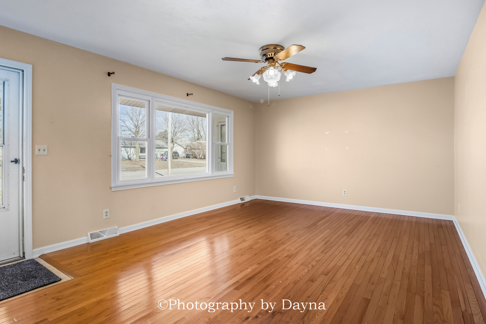 711 Sycamore Street Watseka, IL 60970 - Photo 4 of 21 a view of an empty room with wooden floor and a window