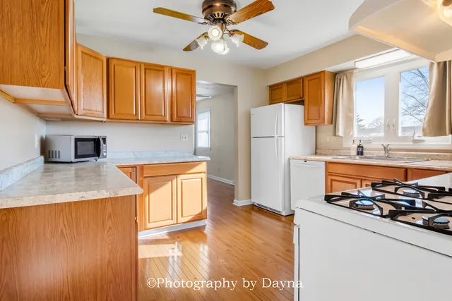 a kitchen with stainless steel appliances granite countertop a refrigerator a stove and a sink with cabinets