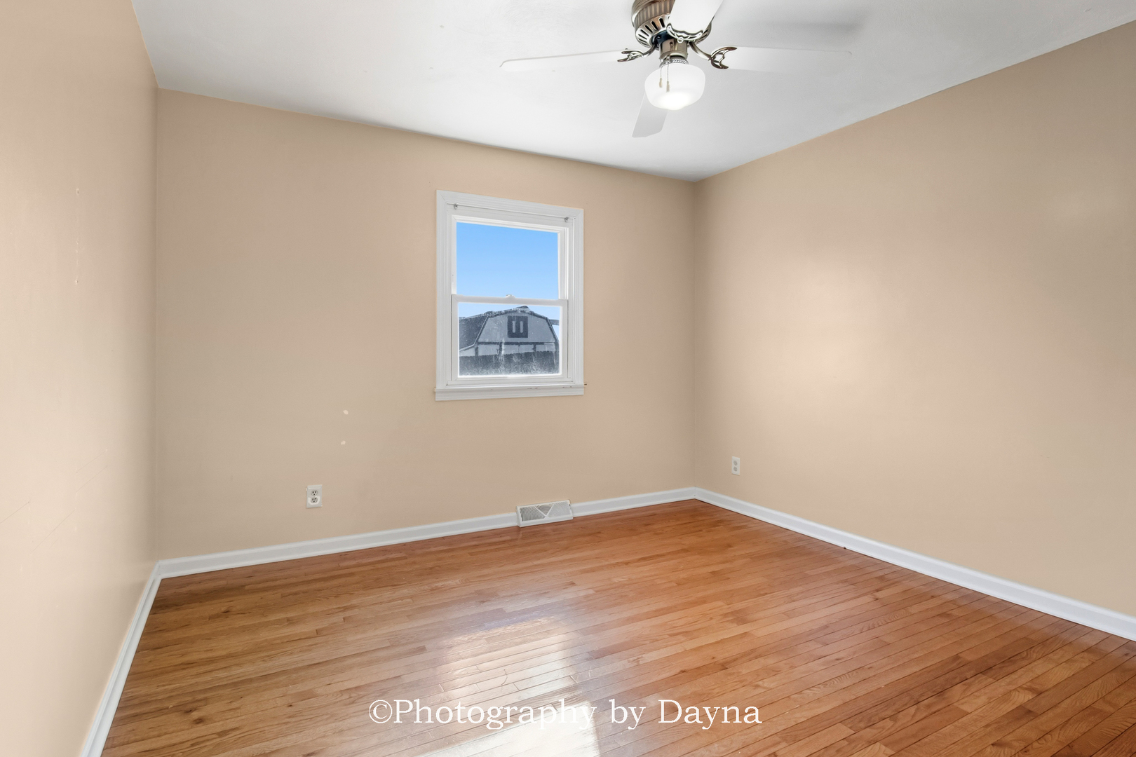711 Sycamore Street Watseka, IL 60970 - Photo 10 of 21 a view of an empty room with wooden floor and a fan
