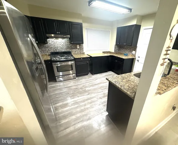 a kitchen with granite countertop a refrigerator and a stove