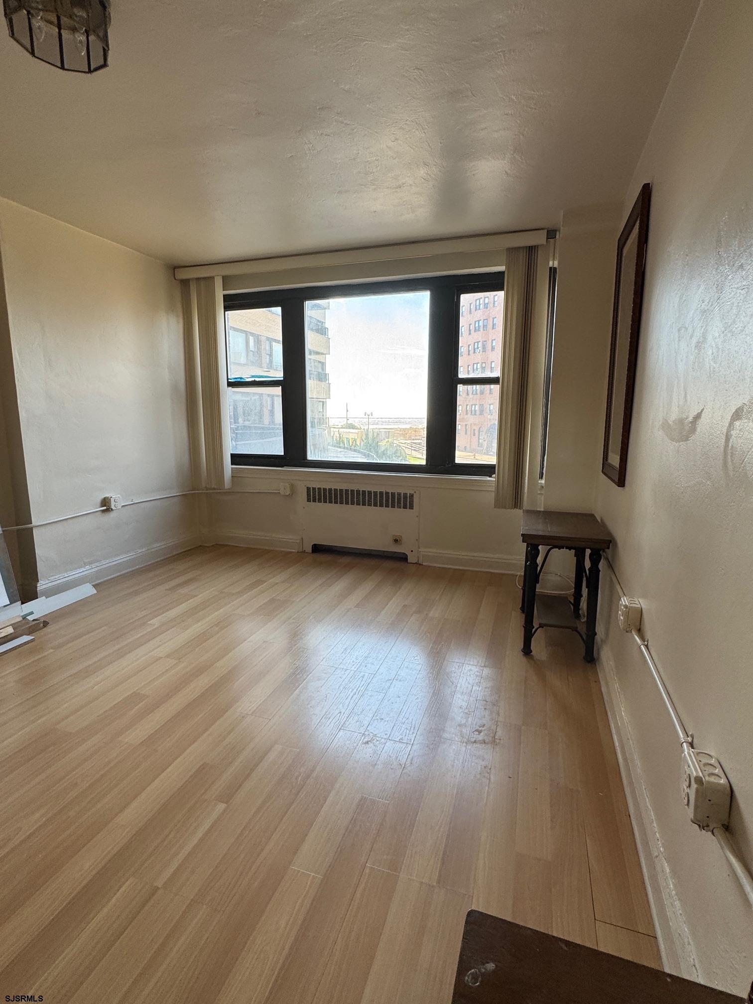 101 South Raleigh Avenue, Unit 210 Atlantic City, NJ 08401 - Photo 11 of 24 an empty room with wooden floor and windows