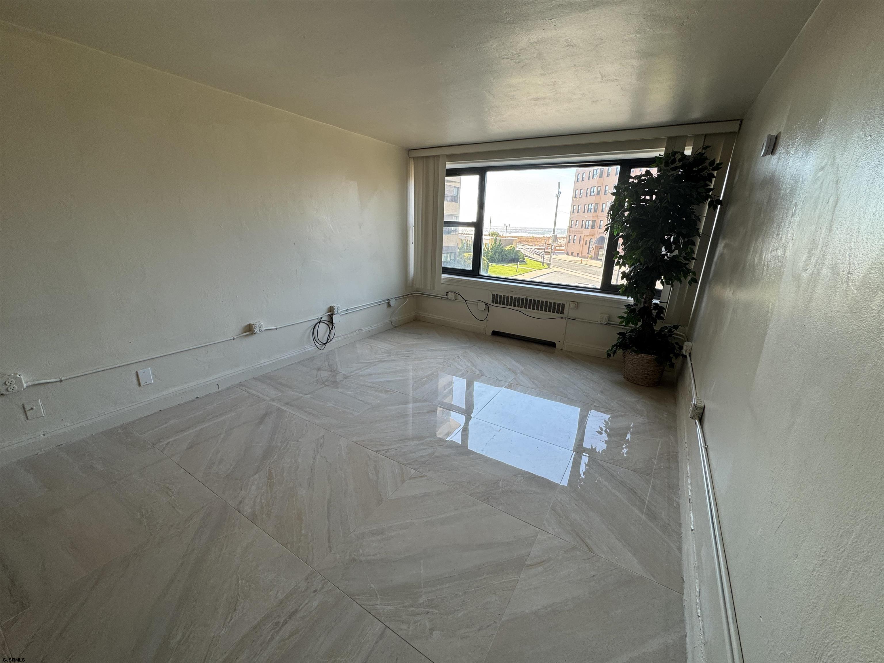 101 South Raleigh Avenue, Unit 210 Atlantic City, NJ 08401 - Photo 9 of 24 a view of an empty room with a fireplace and a window