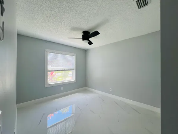 an empty room with window and mirror