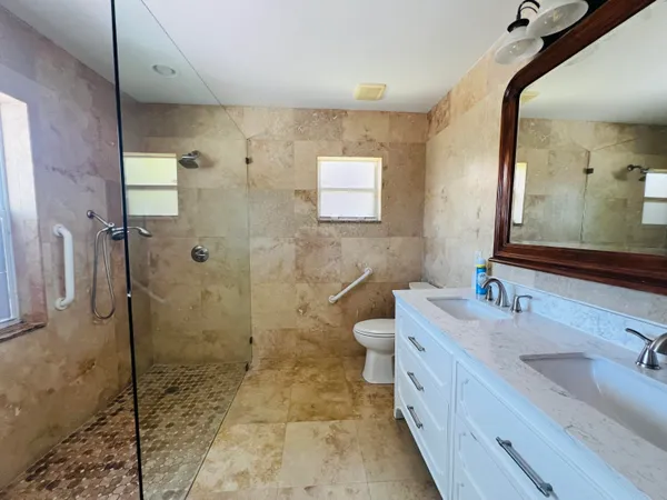 a spacious bathroom with a granite countertop sink mirror and shower