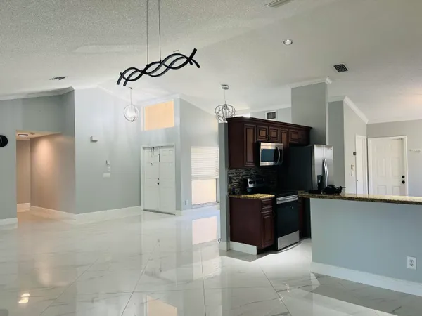 a kitchen with granite countertop a refrigerator and a stove top oven