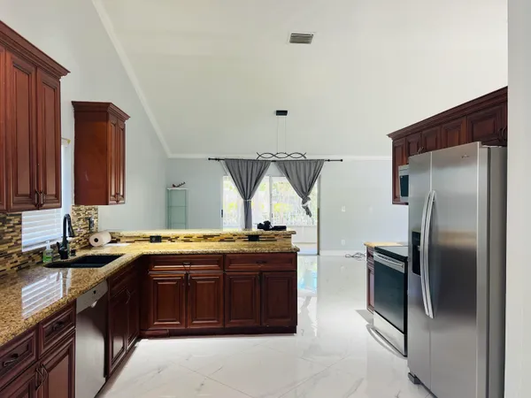 a kitchen with stainless steel appliances granite countertop a sink stove and refrigerator