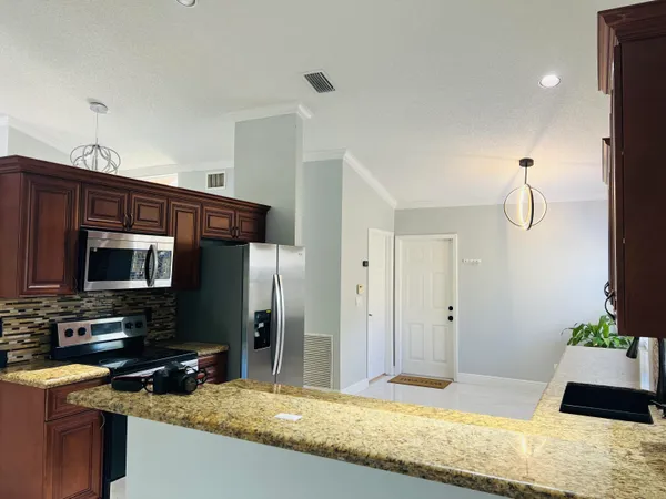 a view of kitchen with sink microwave and refrigerator