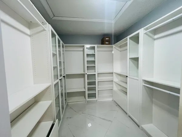 a view of walk in closet with empty racks