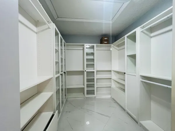 a view of walk in closet with empty racks