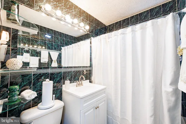 a bathroom with a sink a toilet and shower curtain