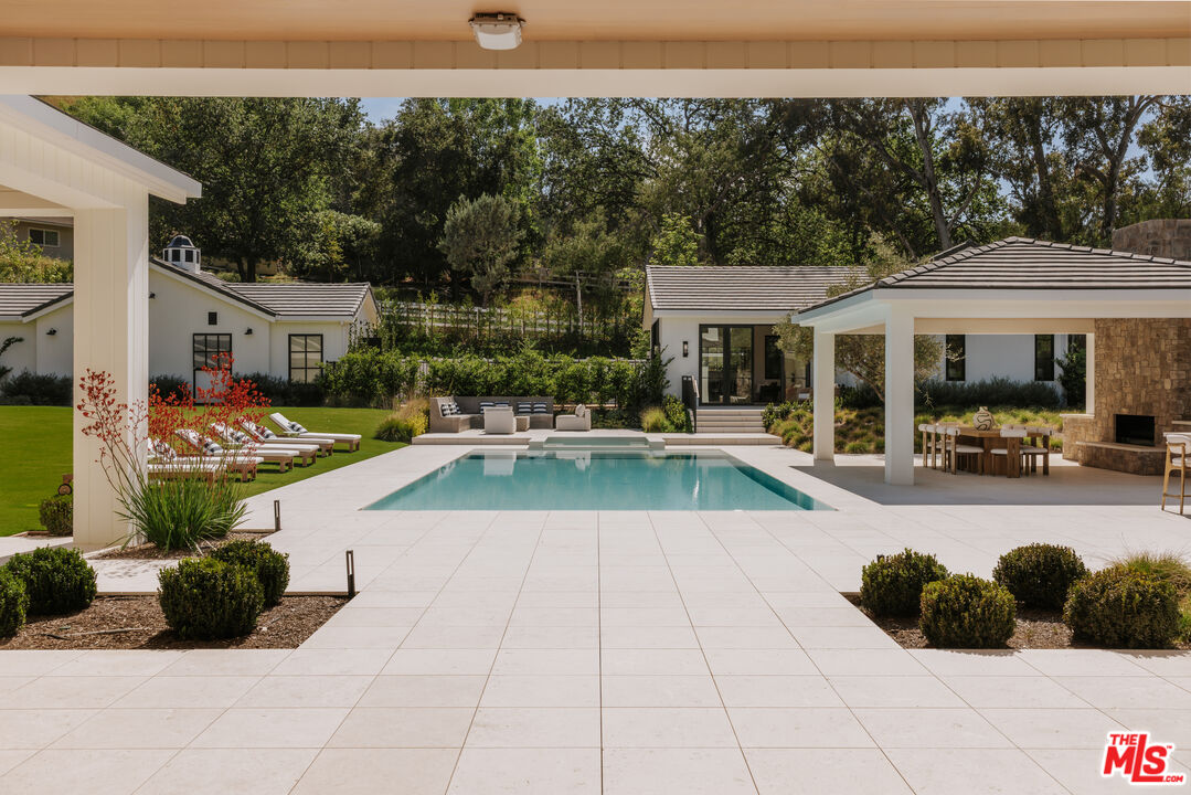 24640 Wingfield Road Hidden Hills, CA 91302 - Photo 11 of 34 a view of a patio with swimming pool table and chairs