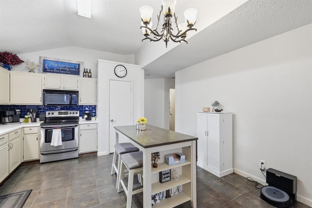 4217 Broken Arrow Road Fort Worth, TX 76137 - Photo 13 of 40 a kitchen with stainless steel appliances a stove a sink and cabinets