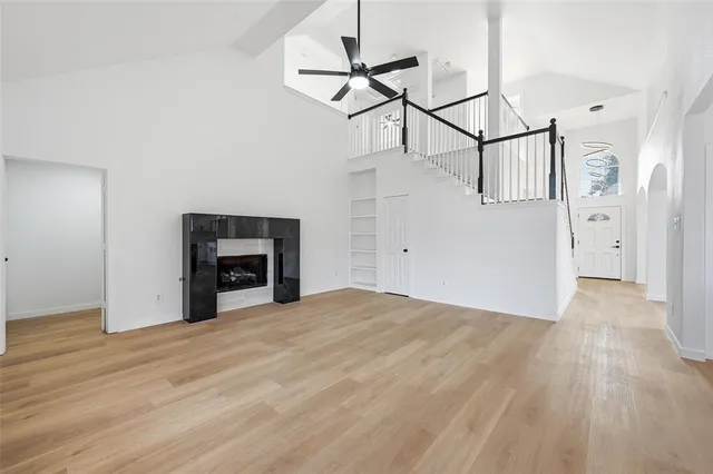 a view of empty room with wooden floor and fireplace