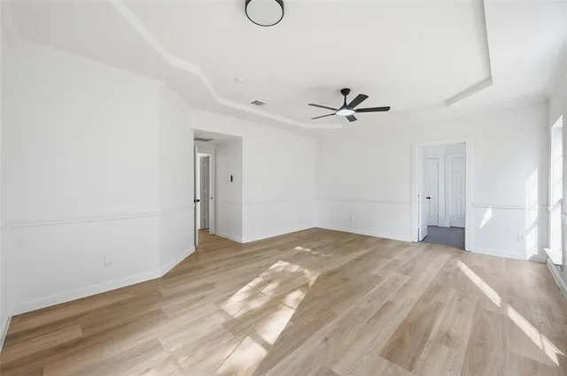 a view of a room with a ceiling fan and wooden floor