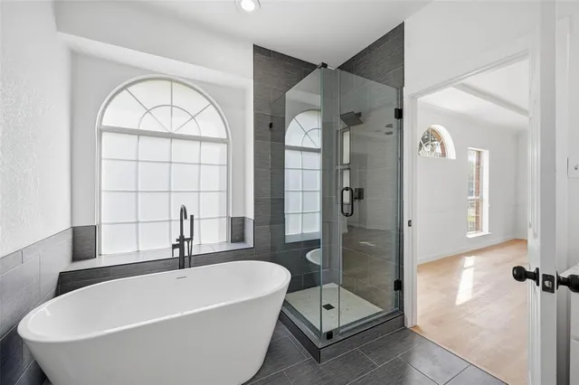 a bathroom with a tub a sink and a window