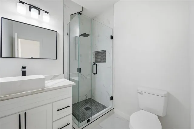a bathroom with a sink toilet and shower