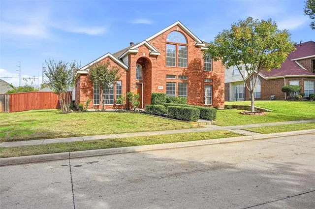 a view of a brick house with a yard