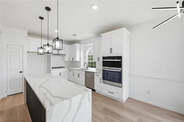 a kitchen with a sink a stove and oven