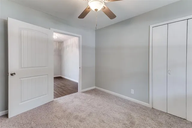 an empty room with closet and a chandelier fan