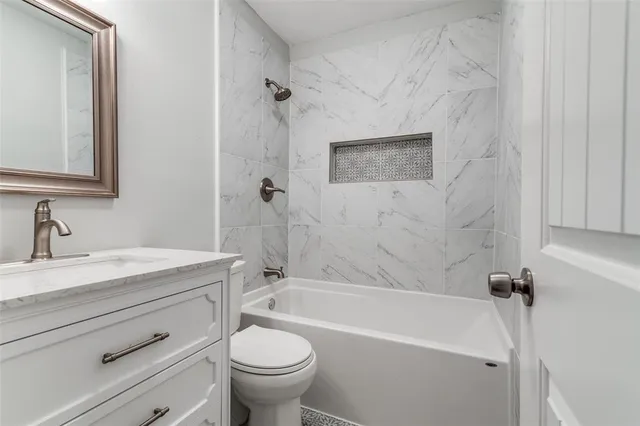 a bathroom with a granite countertop sink toilet and bathtub