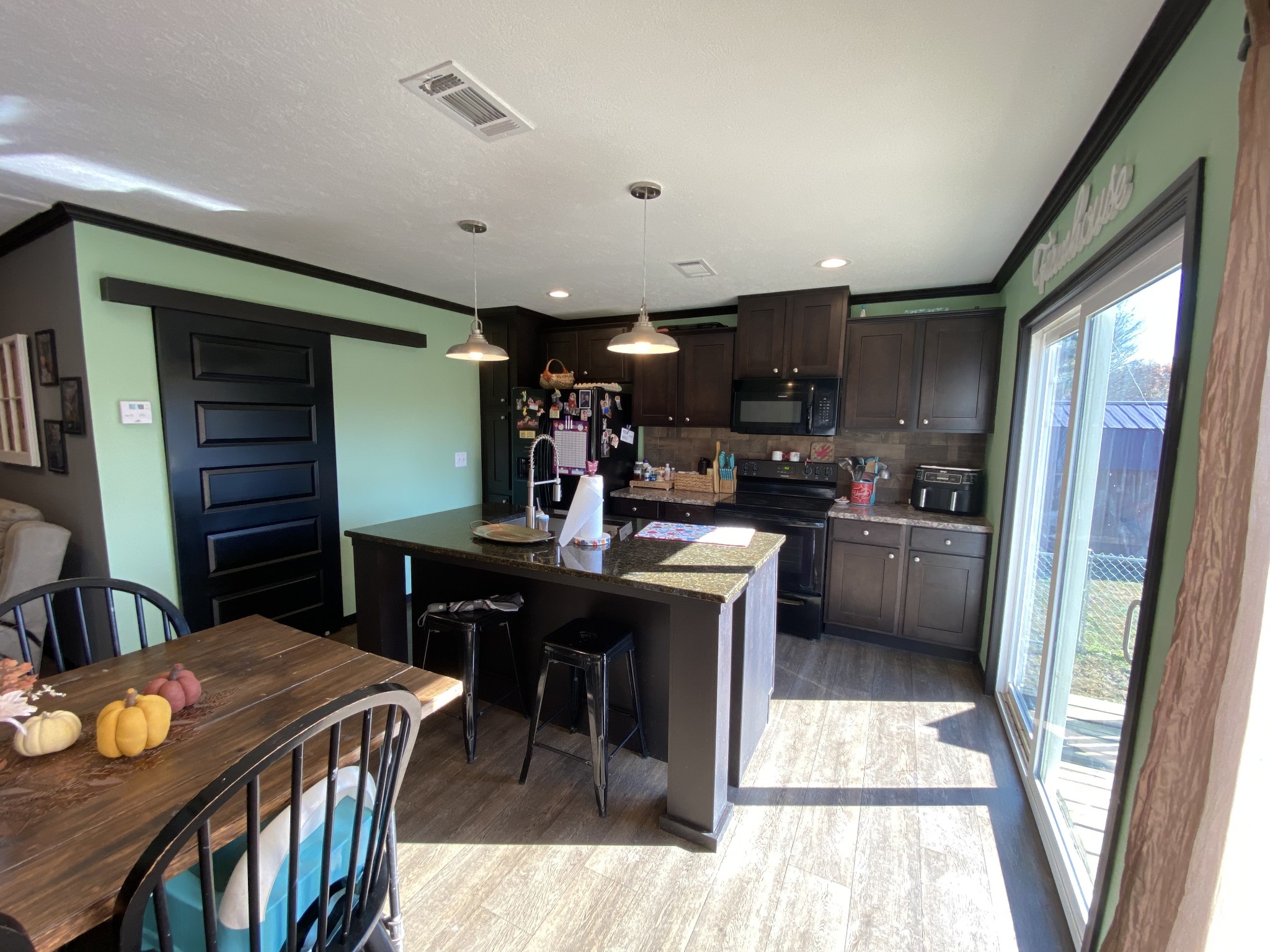 255 Rascal Town Road Loretto, TN 38469 - Photo 30 of 54 a kitchen with stainless steel appliances kitchen island granite countertop a refrigerator a stove a sink a dining table and chairs with wooden floor