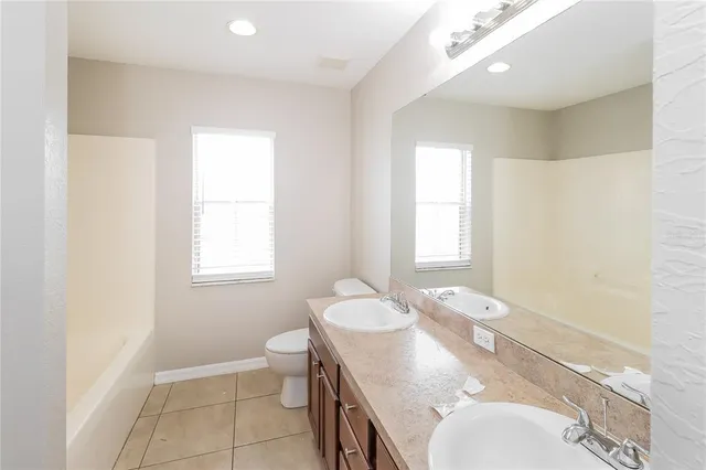 a bathroom with a granite countertop sink a mirror and a toilet