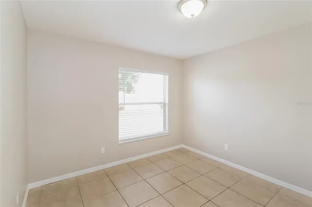 an empty room with fan and windows