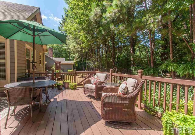 a balcony with wooden floor table and chairs