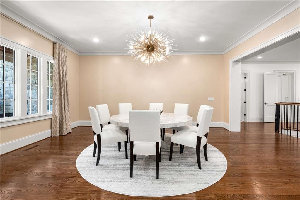 2340 Thisel Down Drive Statham, GA 30666 - Photo 7 of 105 a dining room with chandelier and wooden floor
