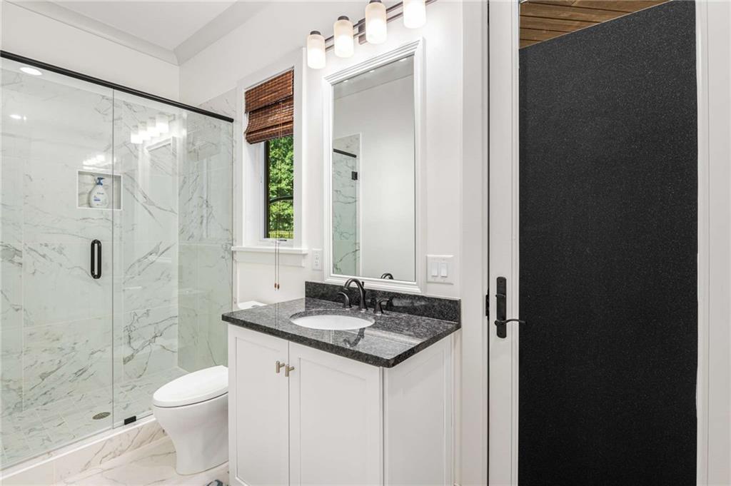 2340 Thisel Down Drive Statham, GA 30666 - Photo 77 of 105 a bathroom with a granite countertop sink toilet and shower