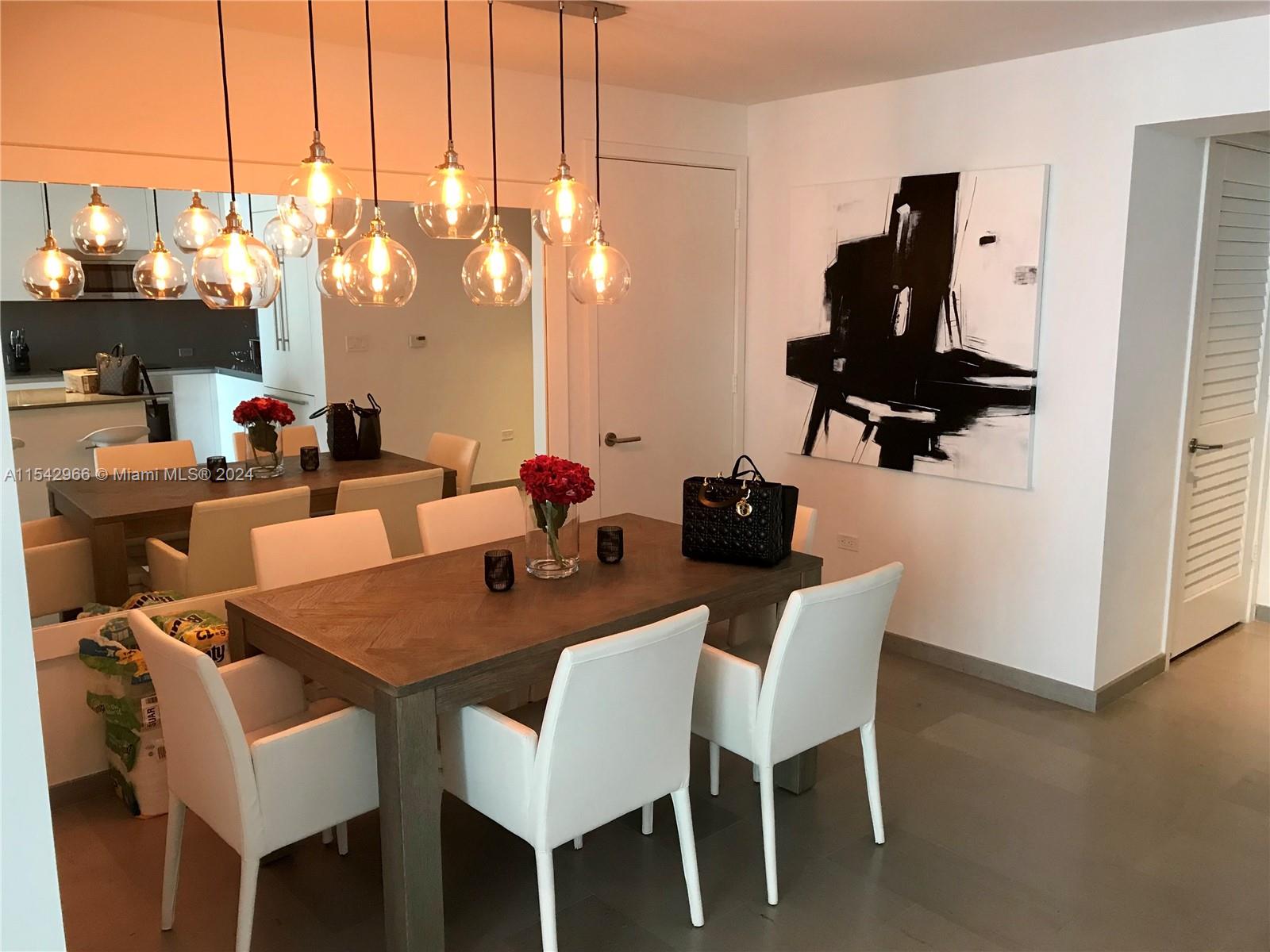 68 Southeast 6th Street, Unit 2707 Miami, FL 33131 - Photo 14 of 53 a view of a dining room with furniture and wooden floor